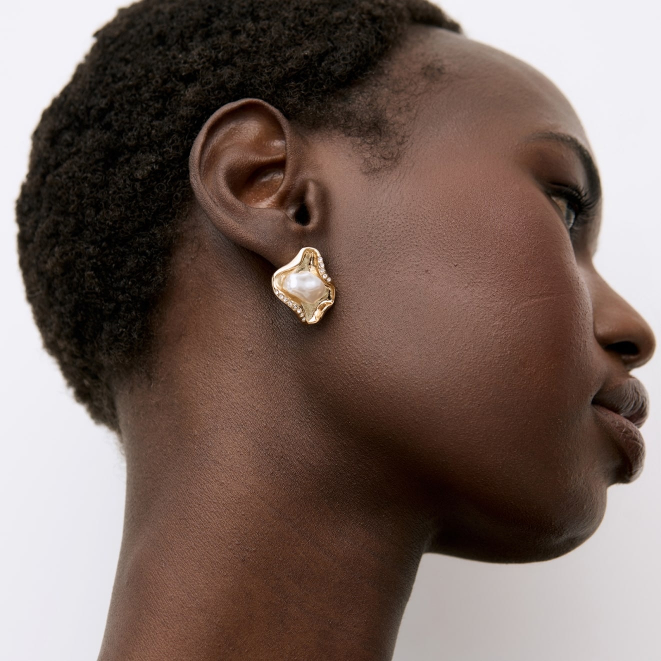 Model wearing shiny silver heart earrings 